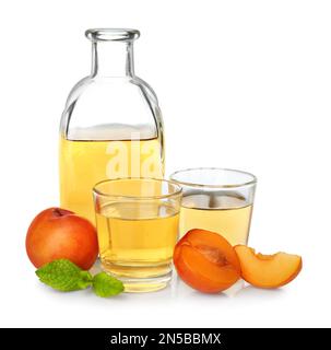 Delicious plum liquor, ripe fruits and mint on white background. Homemade strong alcoholic beverage Stock Photo