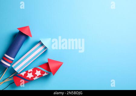 Firework rockets on light blue background, flat lay. Space for text Stock Photo