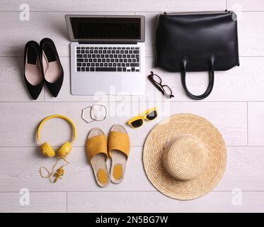 Flat lay composition with business supplies and beach accessories on white wooden floor. Concept of balance between work and life Stock Photo