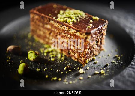 Chocolate cake with walnuts and pistachio isolated on black background. Pastry from homemade bakery Stock Photo