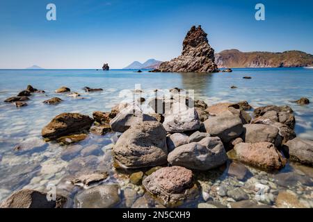 Volcanic bay with a view of the stack and Lipari and Salina in the background, Vulcano Stock Photo