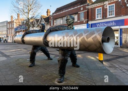 David Annand sculpture of two men carrying a roll of lino, called Roll out the Lino, Staines-upon-Thames High Street, Surrey, UK Stock Photo