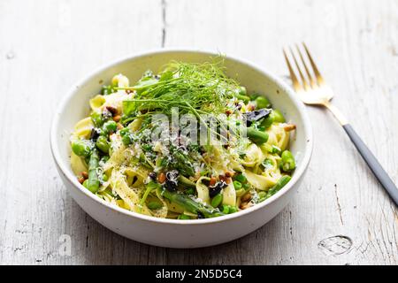 Tagliatelle pasta with asparagus, green peas and broad beans Stock Photo