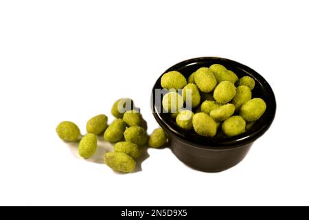 Wasabi peanuts in a black bowl on a white backgrounds Stock Photo