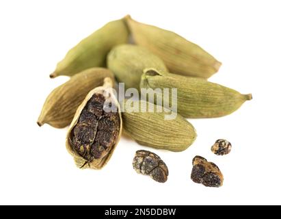 Soft focus on green cardamom seeds and pods on white background. The cardamom pods are blurred in the background. Stock Photo