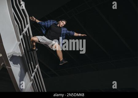 Athlete practicing freerunning doing big scary jump. Parkour like lifestyle Stock Photo