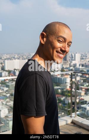 Portrait of handsome bald man wearing t-shirt against plain background Stock Photo