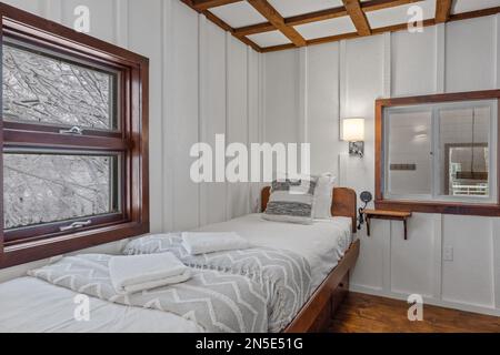Two small beds in a white bedroom next to each other Stock Photo
