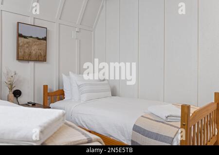 Two small beds in a white bedroom next to each other Stock Photo