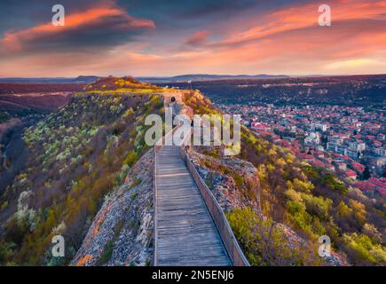 Blooming cherry trees on the hills of Ovech Fortress. Aerial spring cityscape of Provadia town, located in a deep karst gorge along the Provadiya Rive Stock Photo