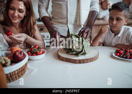 Mixed race family with white son infant swarthy daughter spend time together morning. African american man with his fair skinned wife kids enjoy healt Stock Photo