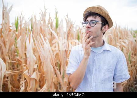 A farmer is thoughtful and worried because the drought has ruined his fields. Stock Photo