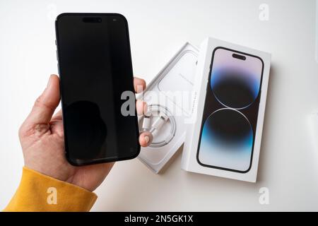 A man holds the latest iPhone 14 Pro Max in Space Black. Apple's latest phone is equipped with three cameras. Stock Photo