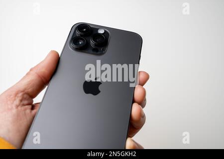 A man holds the latest iPhone 14 Pro Max in Space Black. Apple's latest phone is equipped with three cameras. Stock Photo