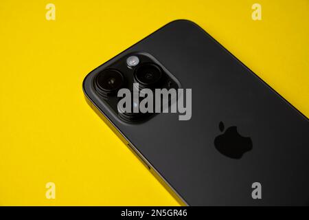 Close-up of iPhone 14 Pro Max space black on isolated yellow background. There are 3 cameras on an island. Stock Photo