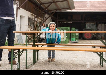 Boy playing around picnic table, Bavaria, Germany Stock Photo