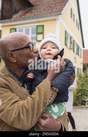 Black senior man kissing his grandson, Bavaria, Germany Stock Photo