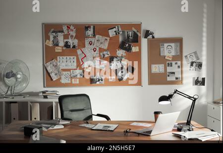 Detective office interior with big wooden desk and evidence board Stock Photo