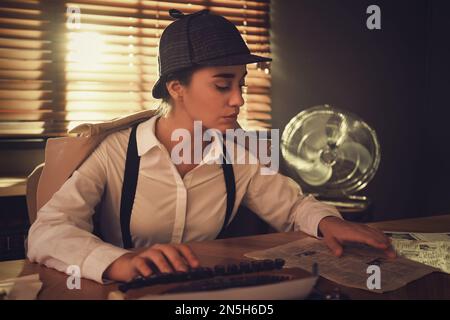 Old fashioned detective using typewriter at table in office Stock Photo