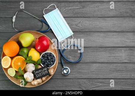 Card with phrase Immunity System, medical items and fresh products on grey wooden table, flat lay. Space for text Stock Photo