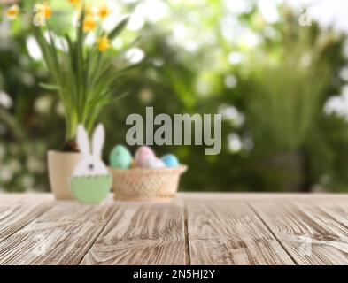 Empty wooden surface and wicker basket with colorful Easter eggs on background Stock Photo