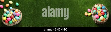 Flat lay composition with colorful Easter eggs on green grass, space for text. Horizontal banner design Stock Photo