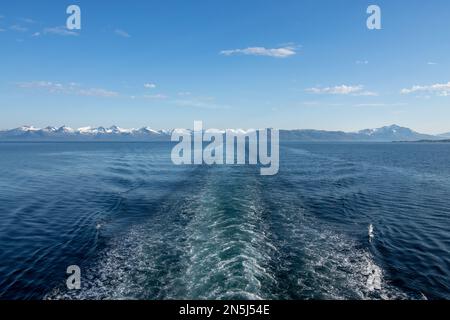 A landscape view of the Haukland Beach in Norway with snow-covered mountains in distance Stock Photo