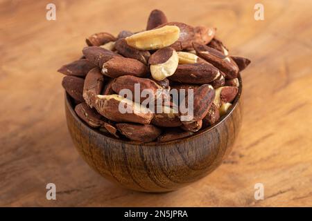 A Bowl of Pili Nuts from the Philippines on a Wooden Table Stock Photo