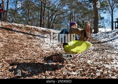 Sebastian Wagner slides off a jump ramp at the bottom of a snow-covered hill on Jan. 30, 2014, in Decatur, Ga. The rare Southern region snowfall left greater metro Atlanta streets clogged with commuters and students taking a few days off. (AP Photo/ Ron Harris)