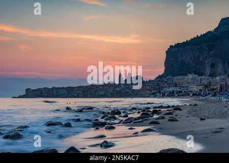 The beach of Cefalù with the town in the background at first morning lights, Sicily Stock Photo