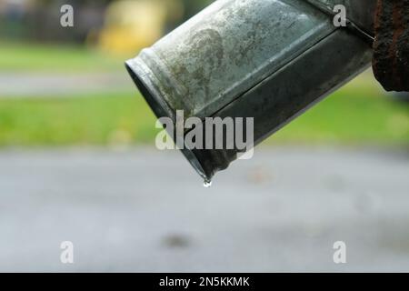 Close-up of Drain pipes and asphalt sidewalk. Bottom of downspout. Stock Photo