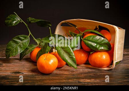 Fresh tangerines with leaves on a wooden background Stock Photo