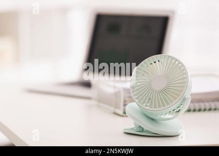 Modern electric fan on table in office. Space for text Stock Photo