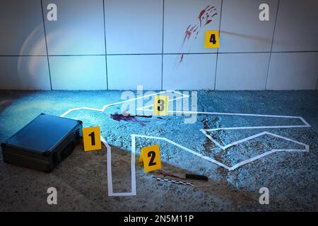 Crime scene with evidences and chalk outline on floor. Detective investigation Stock Photo