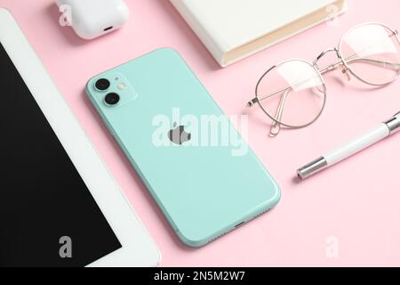MYKOLAIV, UKRAINE - JULY 10, 2020: Composition with Iphone 11 Green and IPad tablet on pink background Stock Photo