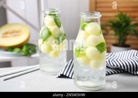 Tasty melon ball drink on light grey table indoors Stock Photo