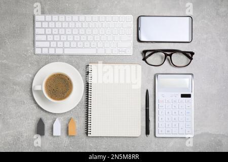 Flat lay composition with computer keyboard, calculator and notebook on grey table Stock Photo