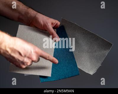 Choosing the fabric which fits to a grey wall. Stock Photo