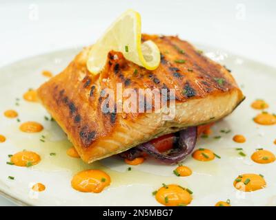 Gourmet grilled Norwegian salmon loin on a mattress of vegetables Stock Photo