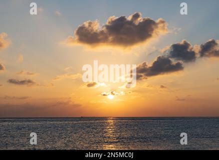 Maldives sunset - tropical sun setting over the Indian Ocean - useful for background or as straight image; Maldives Asia Stock Photo