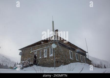 Old mountain snow-covered hut. Meteorological observatory on Mount Pozhyzhevska, Chornohora Stock Photo