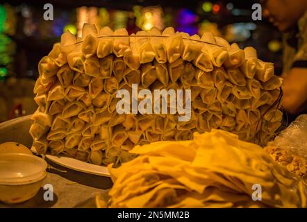 A pile display of spring rolls by night in Hoi An, Vietnam. Stock Photo