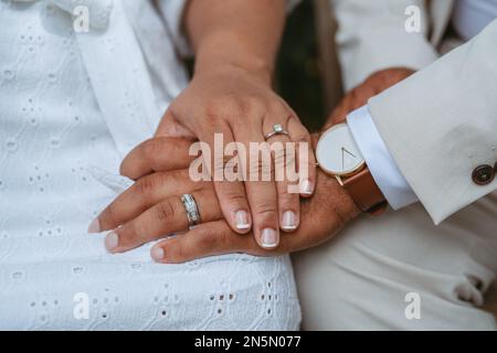 A closeup shot of a bride and groom with their hands with rings held together Stock Photo