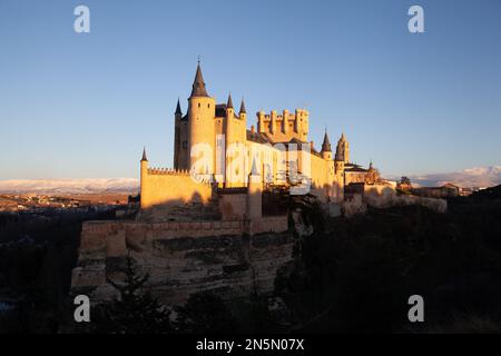 Segovia, Spain - 4 January 2022: Alcazar of Segovia during golden hour on a winter day with Guadarrama Mountains in the background Stock Photo