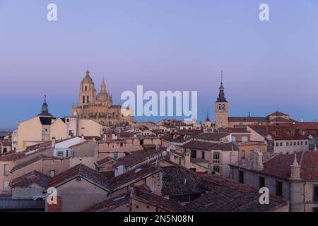 Segovia, Spain - 4 January 2022: Panoramic view of Segovia with the towers of cathedral at sunset with purple sky in winter with Guadarrama Mountains Stock Photo