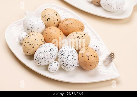 Easter eggs on plate over beige background. Chicken and quail eggs Stock Photo