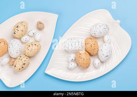 Easter eggs on plate over blue background. Chicken and quail eggs. Flat lay Stock Photo