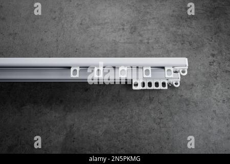 Stripped metal eaves of white color, on a gray concrete wall Stock Photo