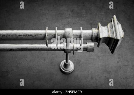 Classic gray wooden eaves with round rings, on a gray concrete wall Stock Photo