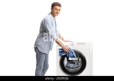 Young man loading a washing machine isolated on white background Stock Photo